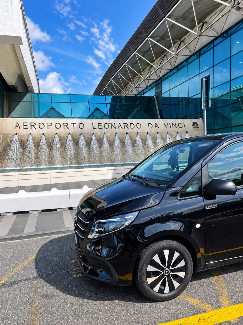 Der schwarze Mercedes Vito Extralong 2026 vor dem Brunnen des Flughafens Leonardo da Vinci in Fiumicino