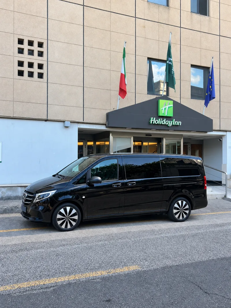 Der schwarze Mercedes Vito Extralong 2026 im Profil vor dem Holiday Inn