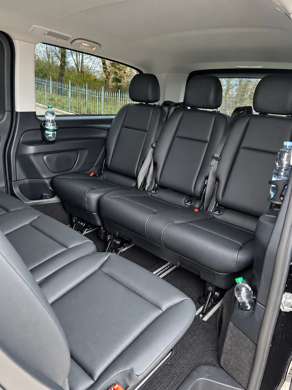 Die Sitzreihen aus Leder im Mercedes Vito, mit Wasserflaschen an Bord